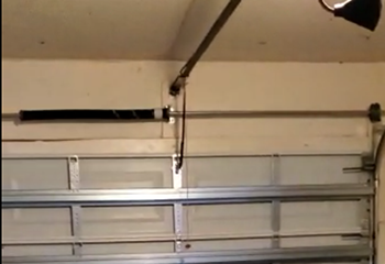 Electric garage door stuck halfway open during repair at Savage home garage.