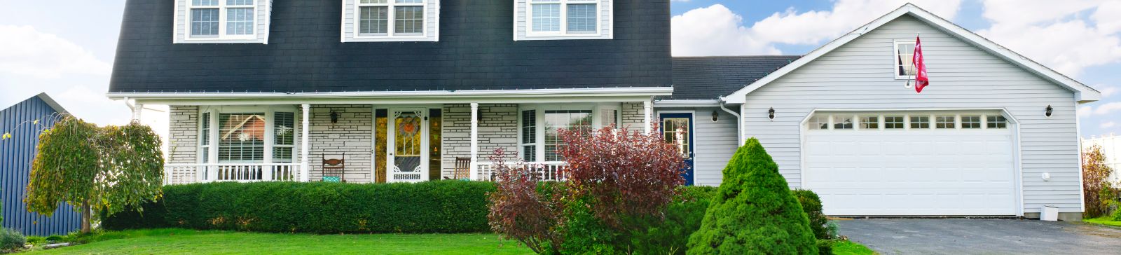 Suburban home with professional garage door installation and landscaped front yard